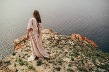 Çayırda beyaz elbiseli genç kız. Güzel bir uzun elbiseli bir çayır üzerinde poz kadın