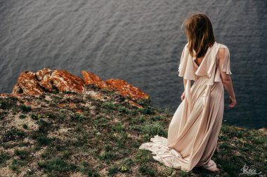 Çayırda beyaz elbiseli genç kız. Güzel bir uzun elbiseli bir çayır üzerinde poz kadın