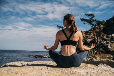 genç kadın dağ gölü yoga uygulamak