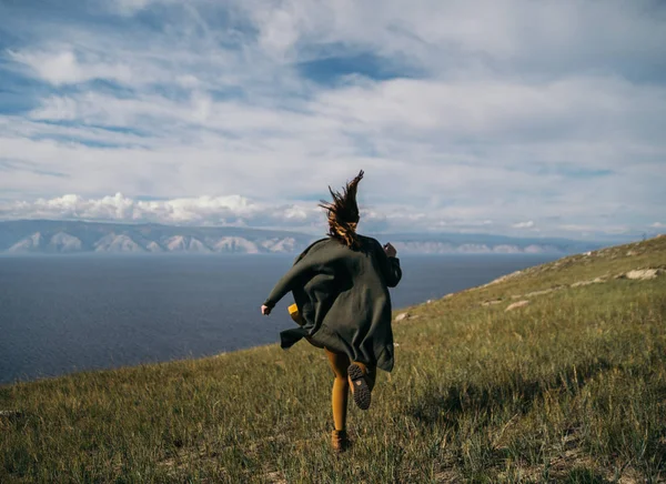 Asiatisk tjej i sportkläder som löper över fältet, morgon träning. Östra tjej gör sport. Sidovy av aktiva atletisk ung kvinna kör på blå himmel bakgrund. Foto med kopia utrymme — Stockfoto