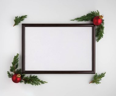 Noel veya Yeni Yıl kompozisyonu. Fotokopi alanı olan fotoğraf çerçevesi, Noel ağacı dalları ve beyaz arka planda Noel topları. Düz yatış, üst görünüm
