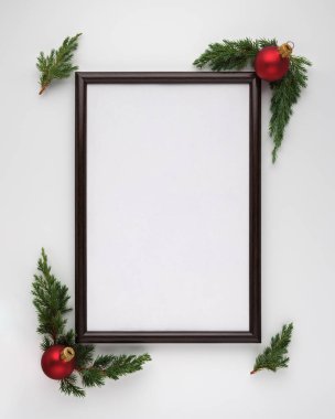 Noel veya Yeni Yıl kompozisyonu. Fotokopi alanı olan fotoğraf çerçevesi, Noel ağacı dalları ve beyaz arka planda Noel topları. Düz konum, üst görünüm, dikey konum