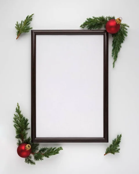 Weihnachts- oder Neujahrskomposition. Fotorahmen mit Kopierraum, Weihnachtsbaumzweigen und Weihnachtskugeln auf weißem Hintergrund. flache Verlegung, Ansicht von oben, vertikale Anordnung — Stockfoto