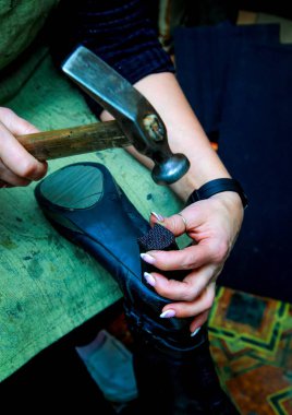 Shoemaker tutan bir ayakkabı ve bir çekiç ve topuk çivilenmiş