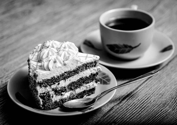 Schwarz-Weiß-Foto einer Tasse Tee und eines Kuchenstücks auf einem Teller — Stockfoto