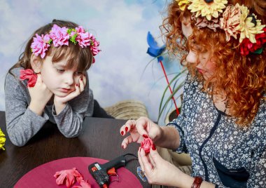 Anne ve kızı güzel çelenk yapay çiçekler kafasına olun.