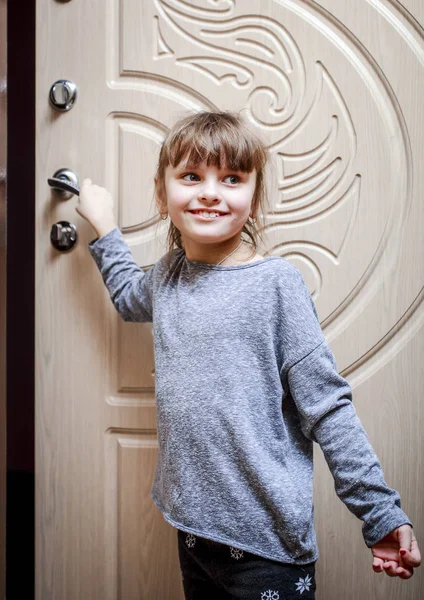 Маленька дівчинка тримає дверну ручку, щоб відкрити її — стокове фото