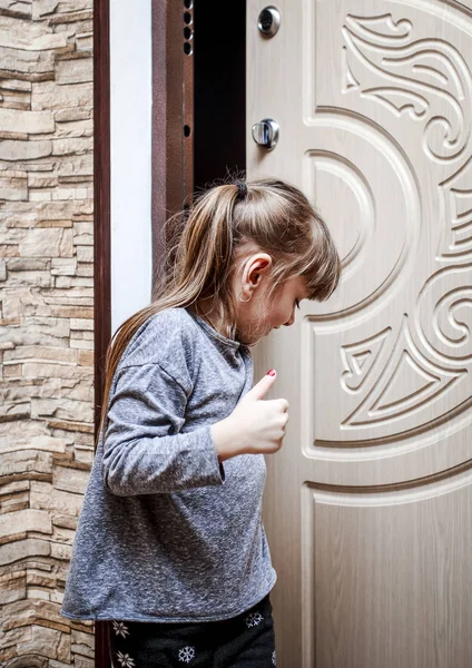 Маленька дівчинка тримає дверну ручку, щоб закрити її і піти в будинок — стокове фото