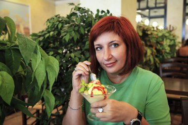 Sevimli genç kadın dondurma Cafe'de yemek.