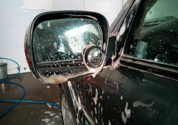 Car wash. Soap foam removed dirt from the side mirror — Stock Photo, Image