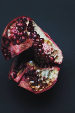 Olgun taze kırmızı nar tohum koyu arka plan üzerinde. Parçalar üzerinde disseke nar.