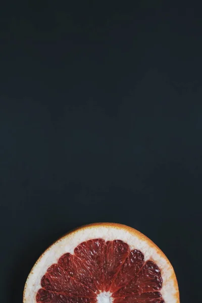 暗い背景に つのグレープ フルーツの半分 ザボンの単一のスライス — ストック写真