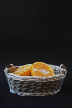 Bir sepet meyve. Yarısı siyah arka plan üzerine portakal. Sepet içinde portakal