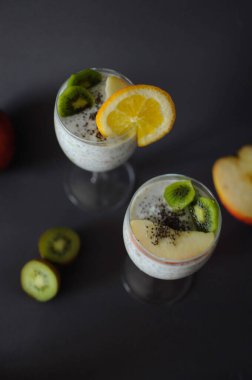Taze meyve ve bal dolu bardakta sağlıklı chia pudingi.
