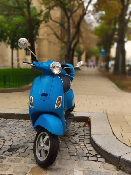 Şehir merkezine park edilmiş klasik mavi renkli scooter.