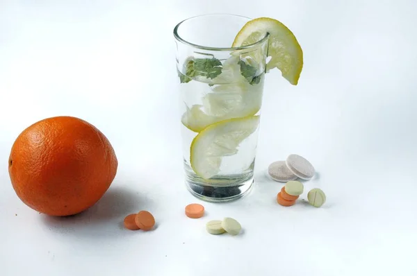 Bicchiere d'acqua con limone, menta e integratori alimentari — Foto Stock