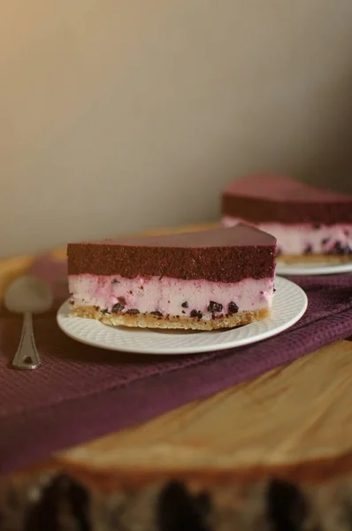 Et stykke hjemmelavet cheesecake med blåbær på hvid tallerken. Mørk baggrund . - Stock-foto