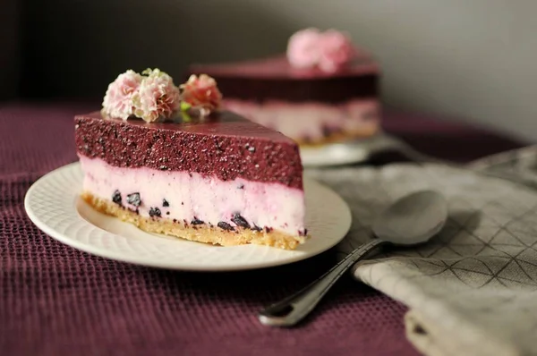 Bitar av ingen bakad blåbär cheesecake på vit platta med lila handduk — Stockfoto
