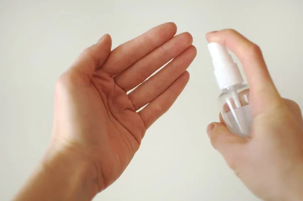 Disinfecting hands after returning from street. Woman sanitaze her hands at home