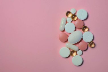 Pembe masadaki farklı haplardan. Bir sürü renkli hap, antiviral ilaçlar da dahil. COVID-19 ve diğer hastalıklara karşı ilaçlar