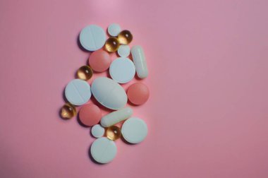 Beyaz masada bir sürü farklı hap var. Bir sürü renkli hap, antiviral ilaçlar da dahil. COVID-19 ve diğer hastalıklara karşı ilaçlar