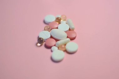 Beyaz masada bir sürü farklı hap var. Bir sürü renkli hap, antiviral ilaçlar da dahil. COVID-19 ve diğer hastalıklara karşı ilaçlar