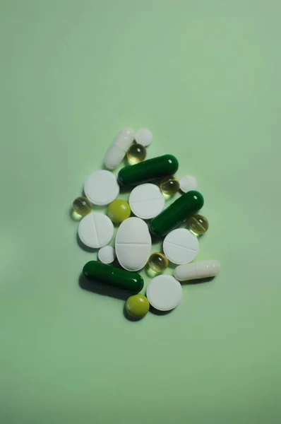 许多不同的药丸放在绿桌上 许多五颜六色的不同药丸 包括抗病毒药物 预防Covid 19和其他疾病的药物 — 图库照片
