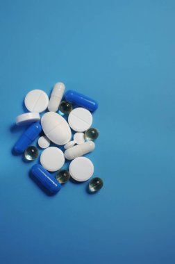 Mavi masada bir sürü farklı hap var. Bir sürü renkli hap, antiviral ilaçlar da dahil. COVID-19 ve diğer hastalıklara karşı ilaçlar