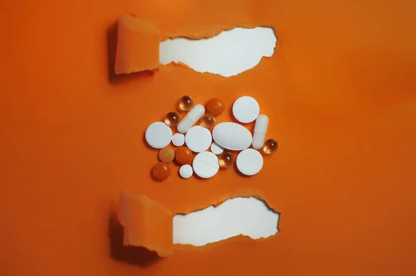 オレンジの背景にタイトルを持つ多くのカラフルな丸薬 抗ウイルス薬を含むカラフルな異なる薬の多く Covid 19その他の疾患に対する薬 — ストック写真