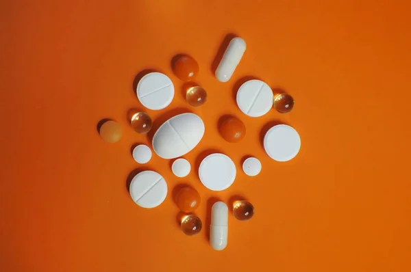 在桔子桌上撒了很多五彩斑斓的药丸 许多五颜六色的不同药丸 包括抗病毒药物 预防Covid 19和其他疾病的药物 — 图库照片