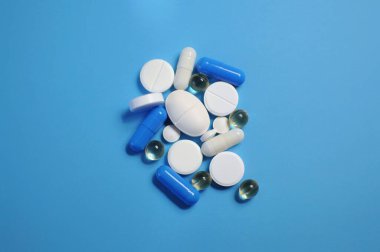 Mavi masada bir sürü farklı hap var. Bir sürü renkli hap, antiviral ilaçlar da dahil. COVID-19 ve diğer hastalıklara karşı ilaçlar