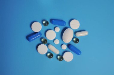 Bir sürü renkli hapla dolu çok geniş bir masa. Bir sürü renkli hap, antiviral ilaçlar da dahil. COVID-19 ve diğer hastalıklara karşı ilaçlar