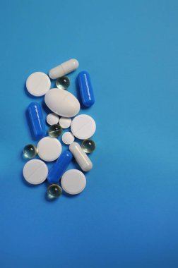 Mavi masada bir sürü farklı hap var. Bir sürü renkli hap, antiviral ilaçlar da dahil. COVID-19 ve diğer hastalıklara karşı ilaçlar