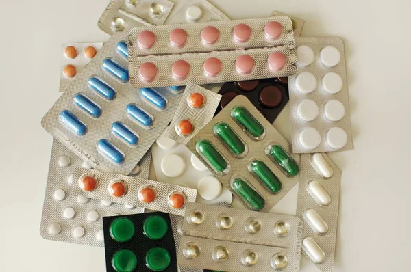 白いテーブルの上に異なる錠剤のブリスター 抗ウイルス薬を含むカラフルな異なる薬の多く Covid 19その他の疾患に対する薬 — ストック写真