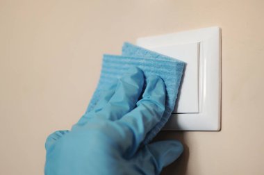 Hastalıkların önlenmesi için evdeki anahtarlar gibi çoğu yeri dezenfekte eden kişi