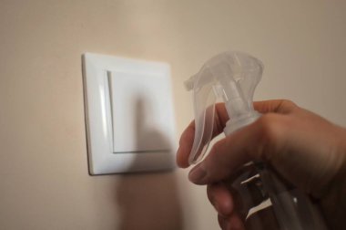Kadının elinde evdeki anahtarlar gibi çoğu yeri temizlemek için dezenfektan var. Hastalıkları önlemek için