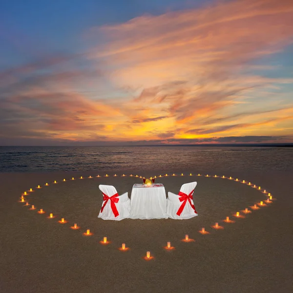 Cena romantica con candele cuore al tramonto spiaggia oceanica. Proposte — Foto Stock