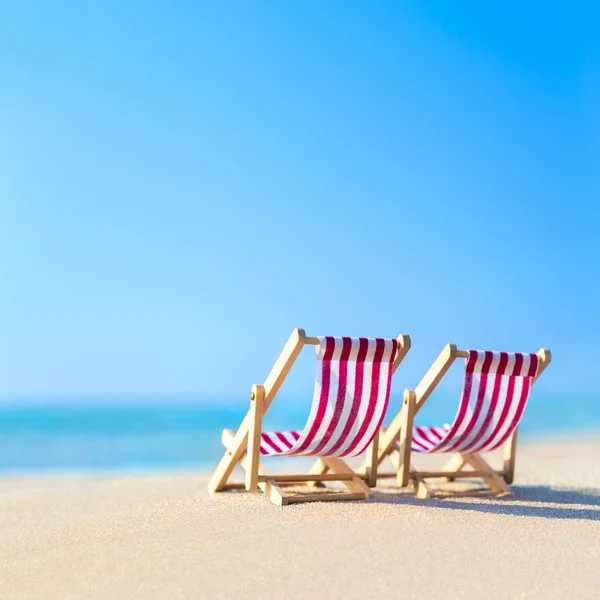 Two striped red-white sunbeds at sandy tropical ocean beach in h — Stock Photo, Image