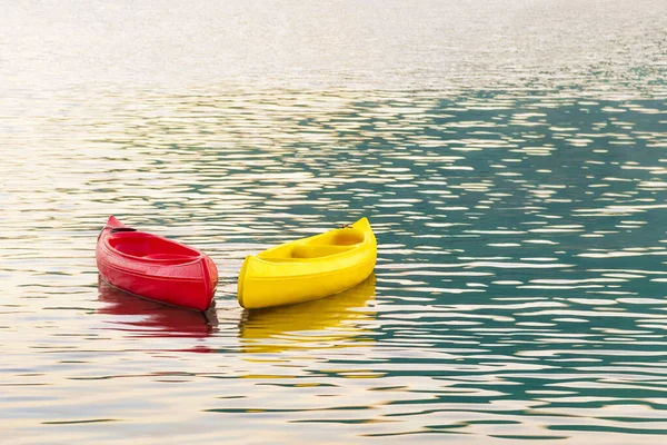 Kayaking. Bright red and yellow kayaks on open sea waves in sunset light. Right Side Copy Space. Water Sports and Summer Recreations outdoor activities Theme.