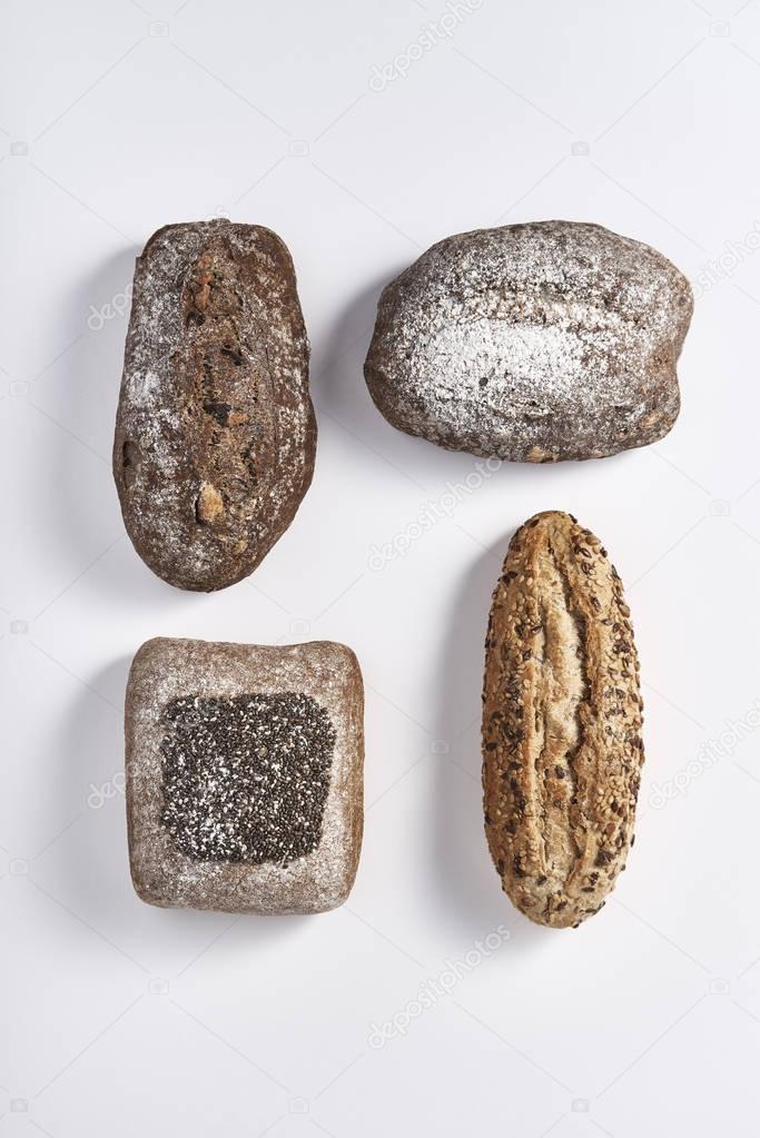 Arrangement of various bread loaves on white