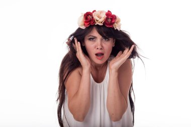 Uzun saçlı esmer bir çelenk çiçek başında ile beyaz bir elbise içinde. Farklı duygular ile fotoğraf. Stil - Ukraynalı kadın.