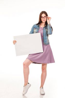 Genç güzel kız için reklam, posta beyaz arka plan ile poz logo. Pembe bir elbise ve denim ceket, spor ayakkabı ve gözlük giymiş. Uzun saçlı. Beyaz arka plan üzerinde izole fotoğraf.