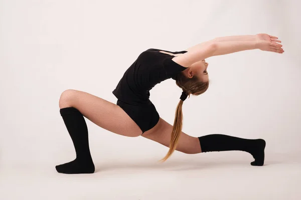 Plasticitet. En flicka utför en övning på flexibilitet. — Stockfoto