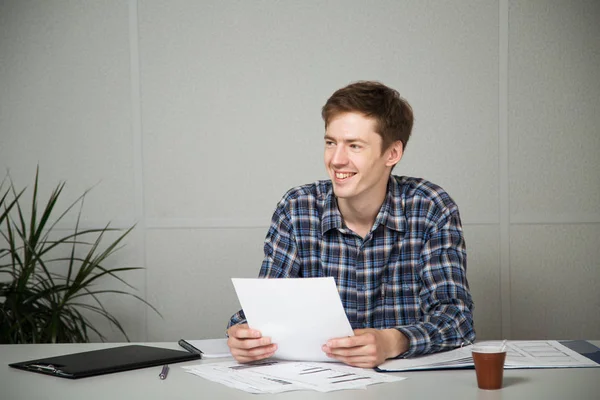 office belgeleri ile masada çalışan genç işadamı