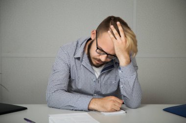 Ofiste bir masada oturan genç iş adamı