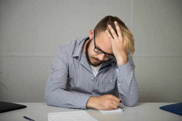 Ofiste bir masada oturan genç iş adamı