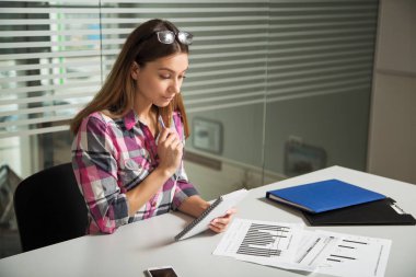 rahat kıyafet oturan gözlüklü genç iş kadını kız tablo bakmak dikkatli belgili tanımlık evrak 