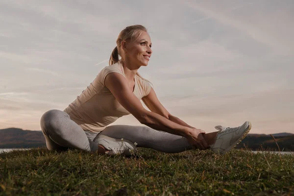 Vacker Kvinna Fitness Instruktör Lätta Kläder Tåg Stranden Mot Himlen — Stockfoto