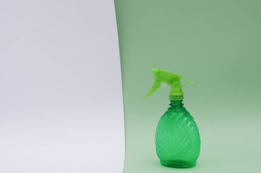 Ev suyu spreyi, yeşil, açık yeşil üzerine beyaz arka planda plastik. İzole edilmiş. Metin için boş alan