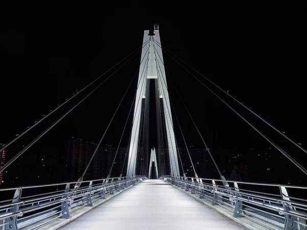 夜の歩道橋をケーブルとどまった — ストック写真